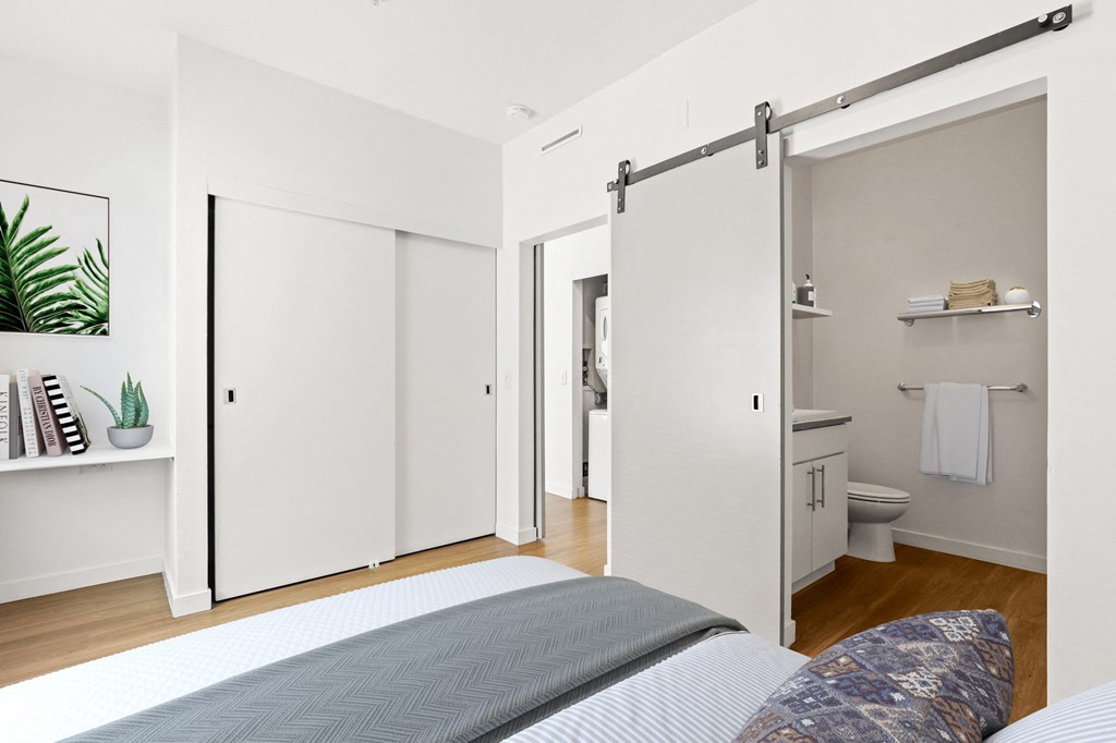 a bedroom with white walls and wood floors