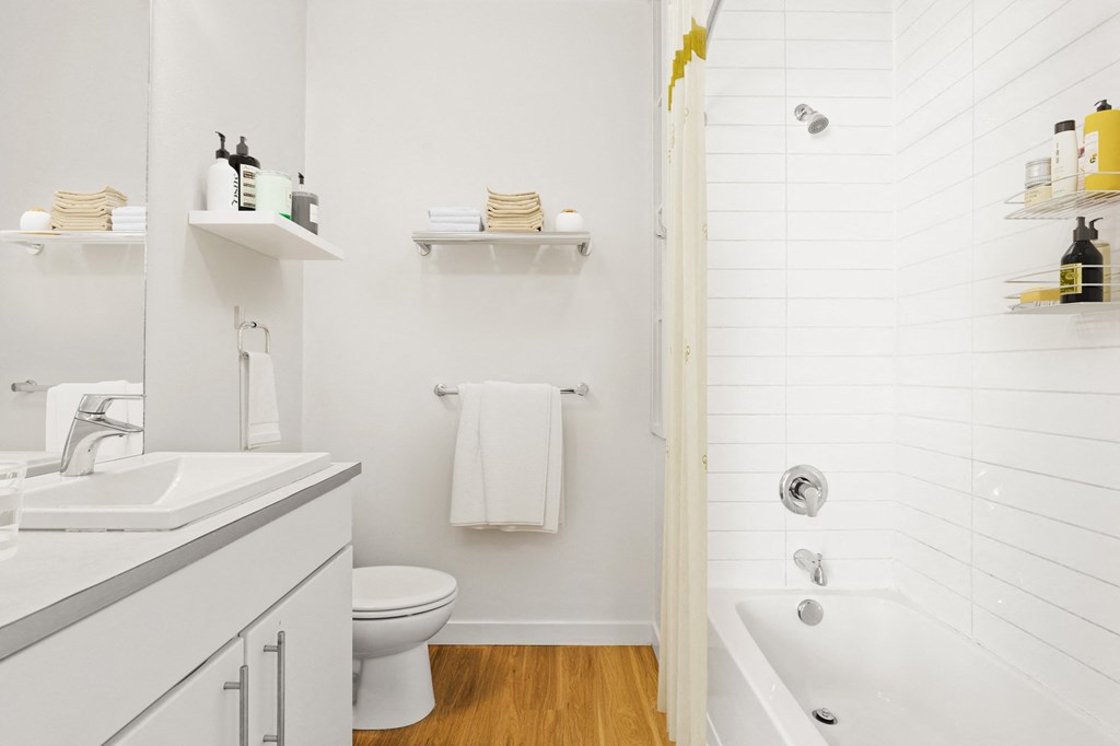 a bathroom with white walls and a wooden floor