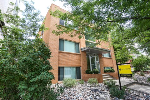 A modern brick house with a green lawn in front.