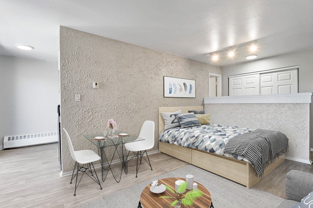 a bedroom with a bed and a table and chairs