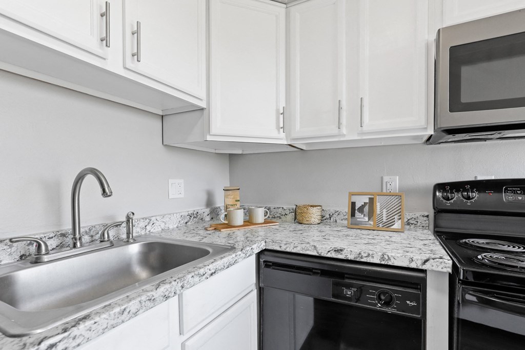a kitchen with white cabinets and granite countertops