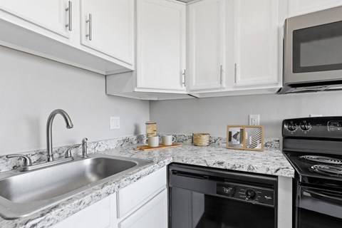 a kitchen with white cabinets and granite countertops