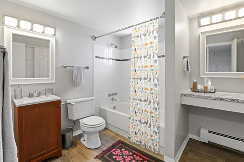 a bathroom with a white toilet next to a bathtub with a shower curtain