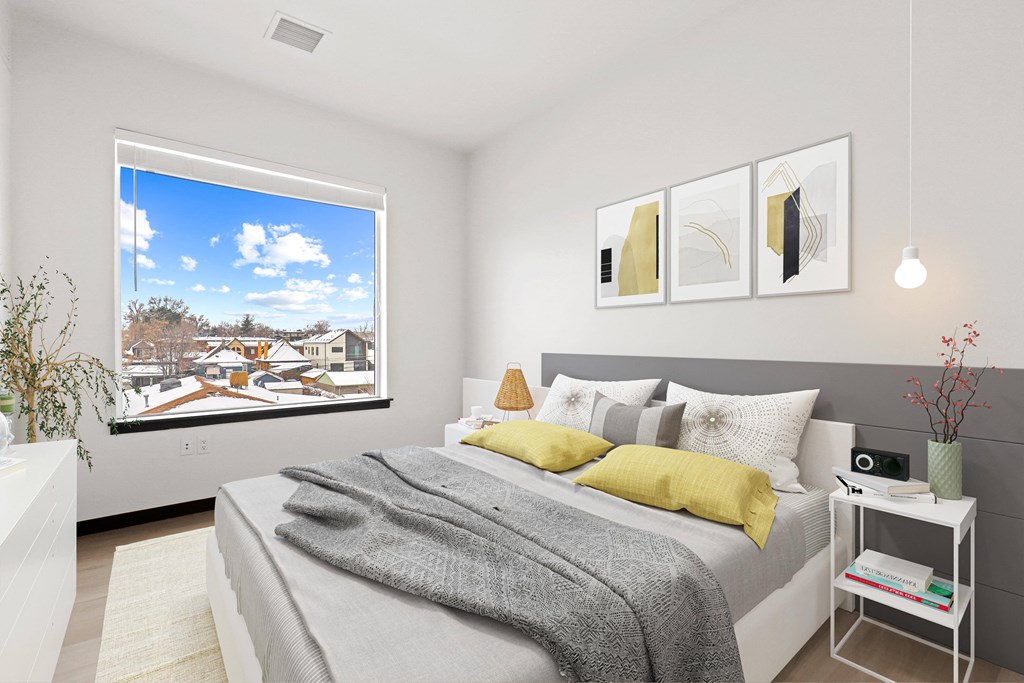 a bedroom with a bed and a large window