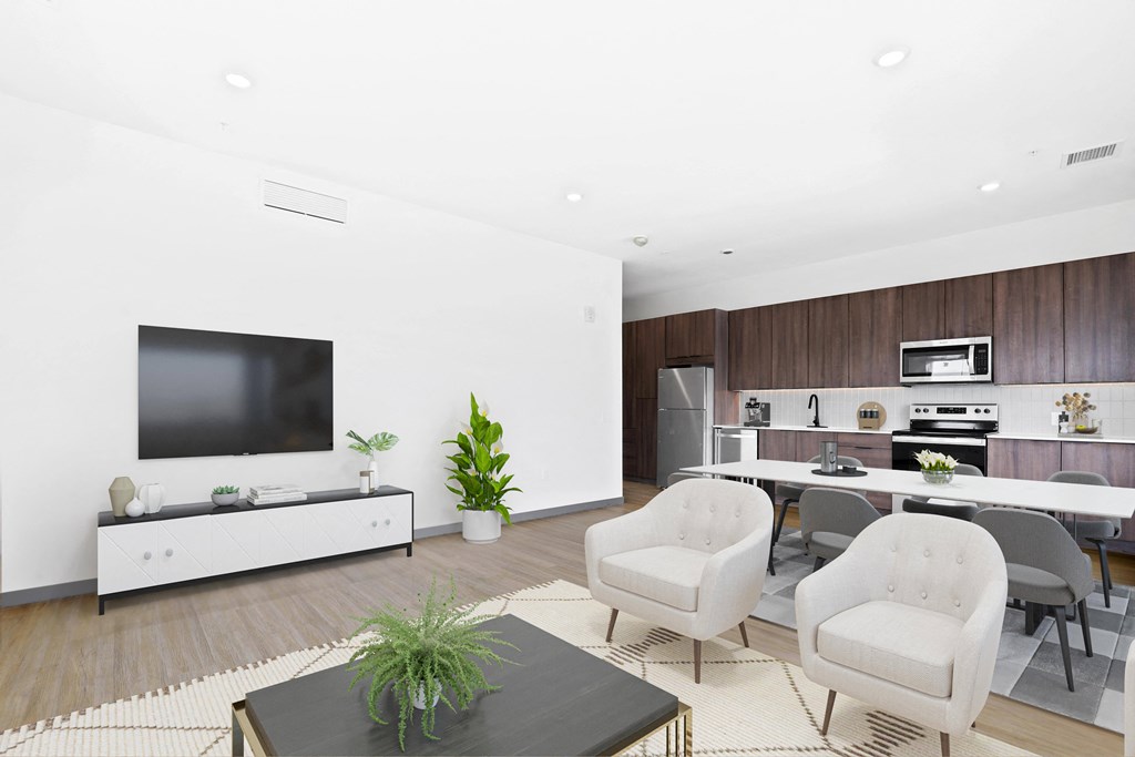 a living room with white furniture and a television