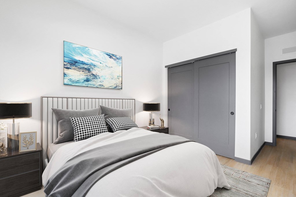 a bedroom with white walls and a bed pillows