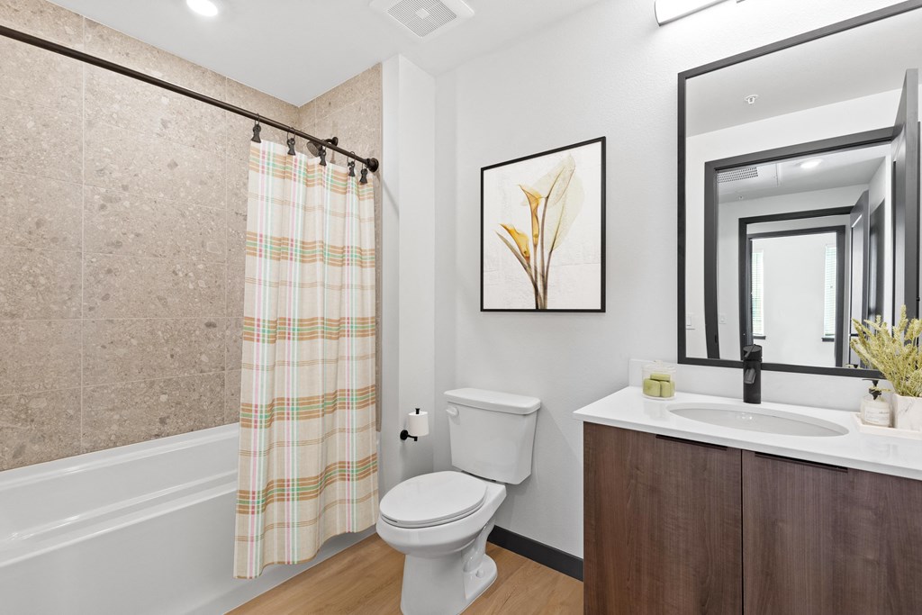 a bathroom with a toilet sink and shower and a mirror