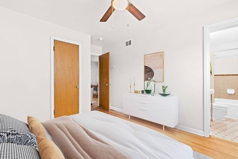 A bedroom with a bed and a ceiling fan.