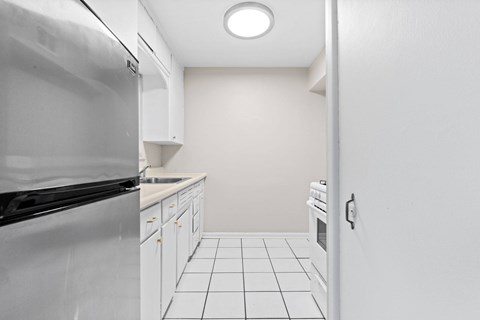 A kitchen with white cabinets and appliances.