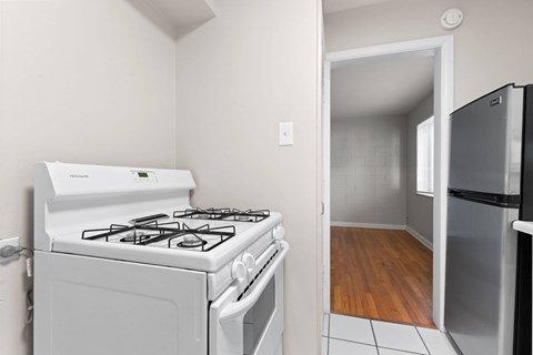 A white stove and oven in a kitchen with a refrigerator.