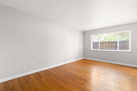 A room with wooden floors and a white brick wall.