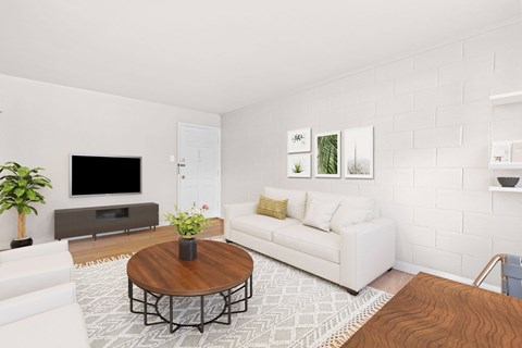 A living room with a white couch, a brown coffee table, and a flat screen TV.