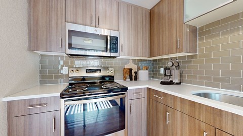 A kitchen with a stove, microwave, and oven.