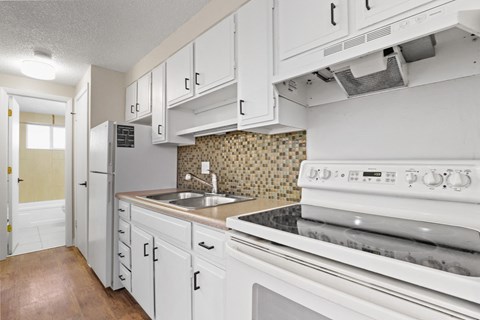 a kitchen with white appliances and white cabinets