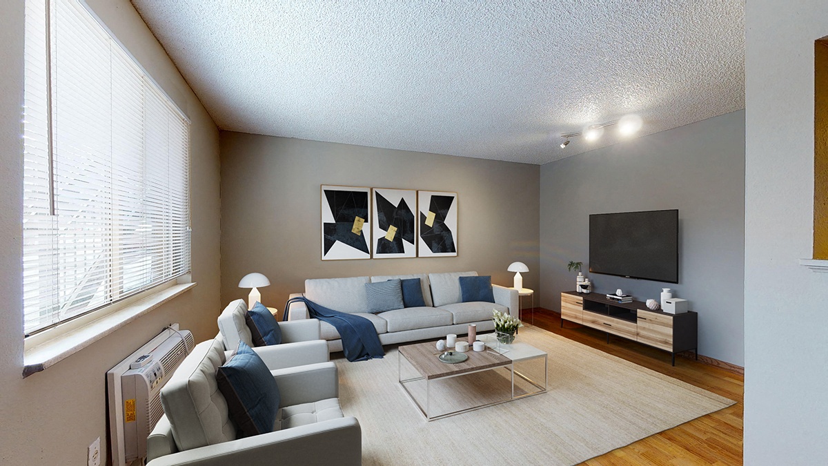 A living room with a grey couch, a coffee table, and a television.