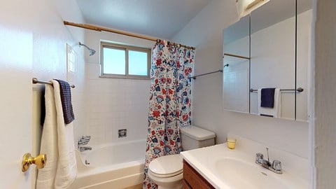 A white bathroom with a toilet, sink, and shower.