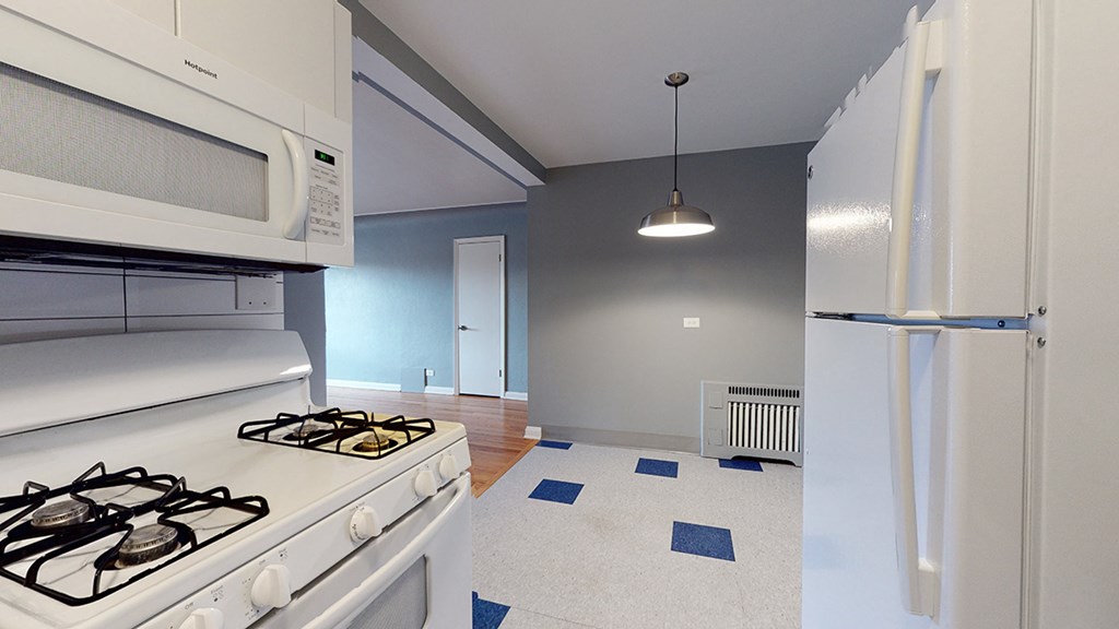 A kitchen with a white stove and a white refrigerator.