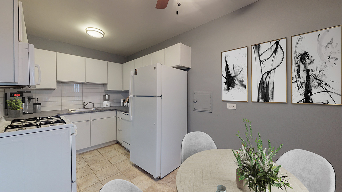 A kitchen with a table and chairs and a wall of art.