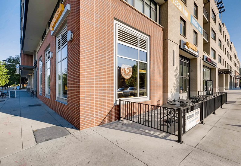A brick building with a black fence in front.