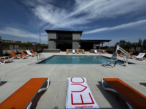 A pool area with loungers and a sign that reads "LivingEVO.com".