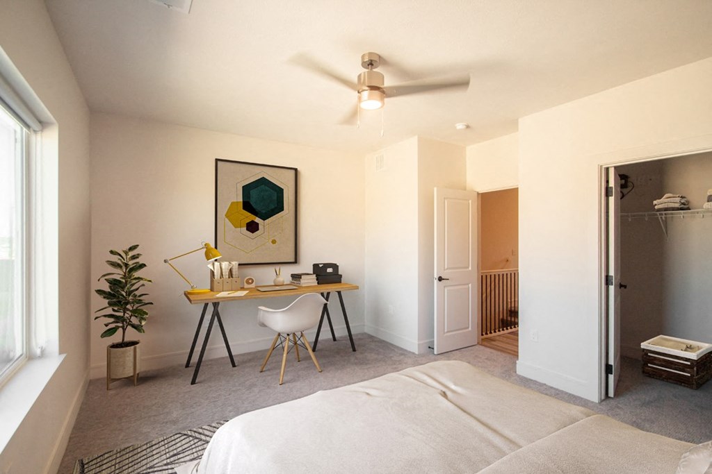 a bedroom with a bed desk and a ceiling fan