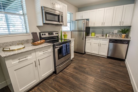 A kitchen with white cabinets and stainless steel appliances.