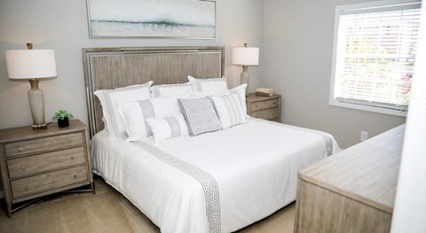 a bedroom with a large bed and two lamps