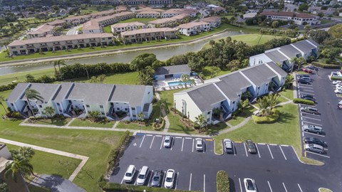 A parking lot with cars and a building in the background.