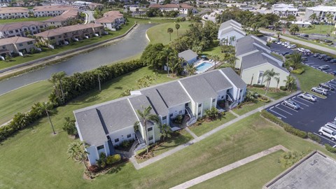 A bird's eye view of a residential area with houses and a parking lot.