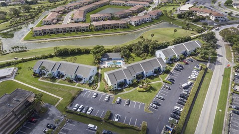 A bird's eye view of a residential area with houses and parked cars.