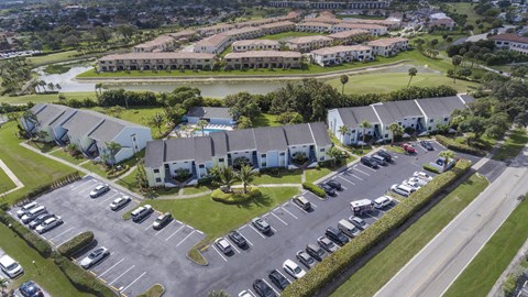 A parking lot with cars and a building in the background.