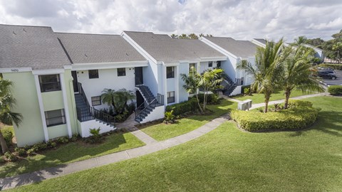 A row of houses with a green lawn in front.