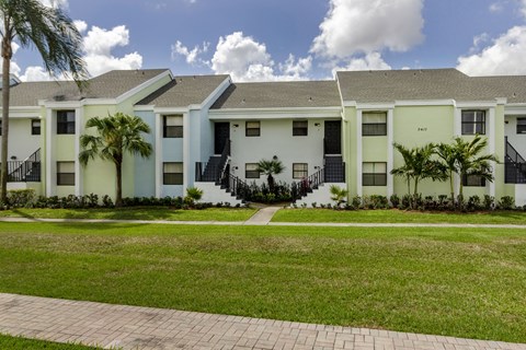 A row of townhouses with a brick pathway in front.