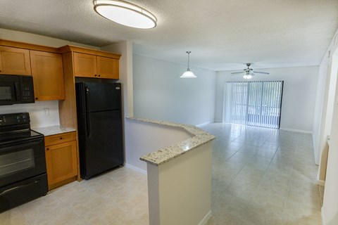 A kitchen with black appliances and wooden cabinets.