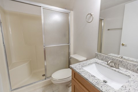 A bathroom with a toilet, sink, and shower.
