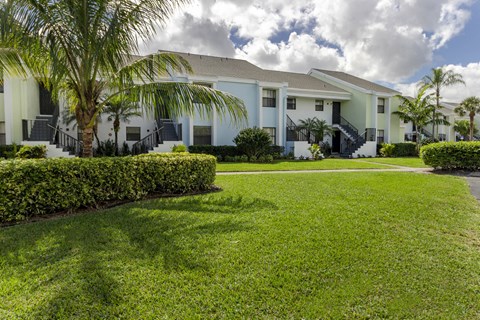 A row of houses with a green lawn in front.