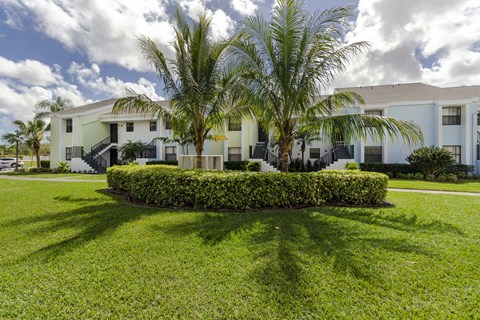 A white building with a green lawn in front.