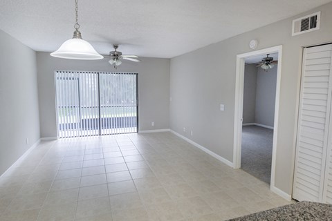 A room with a ceiling fan and a window with blinds.