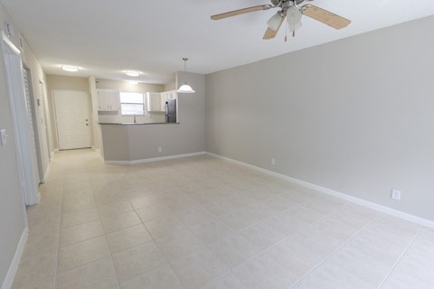 A spacious room with a ceiling fan and tiled flooring.