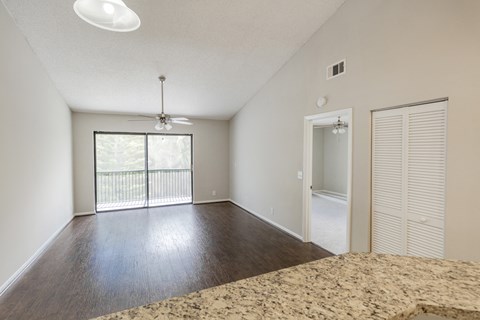 A room with a ceiling fan and sliding glass doors.