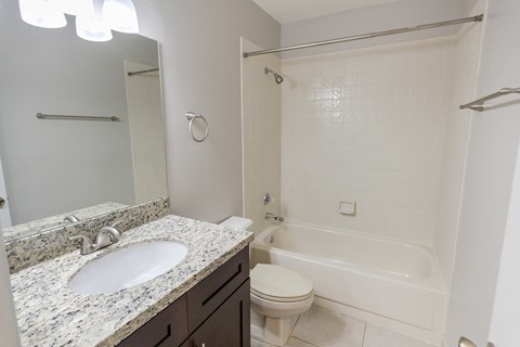 A white bathroom with a sink, toilet and bathtub.