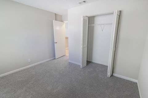 A room with a grey carpet and a white door.