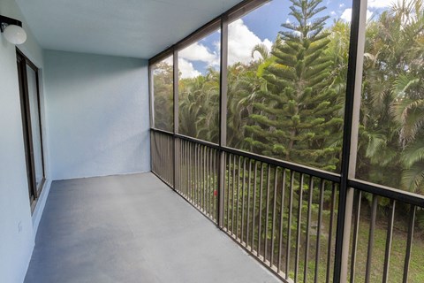 A balcony with a view of trees and sky.