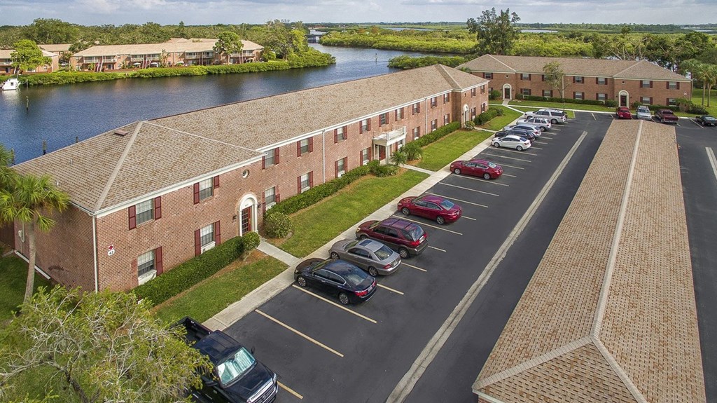 an aerial view of a building with cars parked in a parking lot