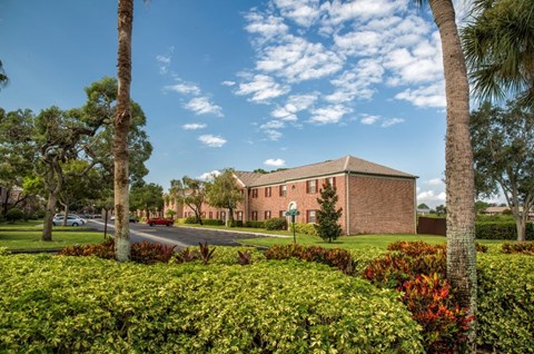 a brick building with palm trees in front of it