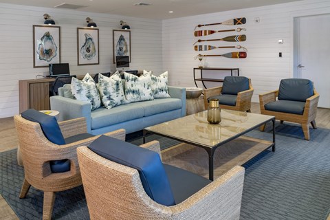 a living room with blue couches and chairs and a table