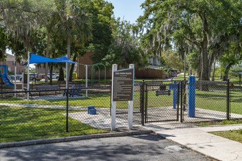 a park with a fence and a sign in front of a playground