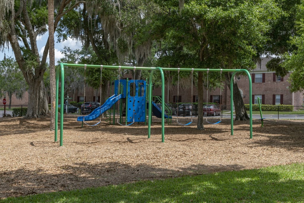 a playground with a blue slide and monkey bars