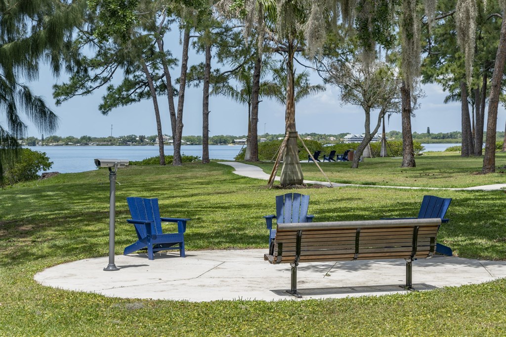 a park bench and two chairs overlooking the water