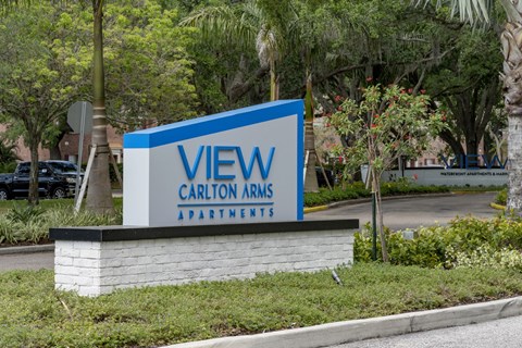 a sign for the view carillon arms apartments in front of a street